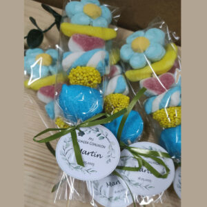 Brochetas de golosinas personalizadas con etiqueta Mi Primera Comunión y lazo verde